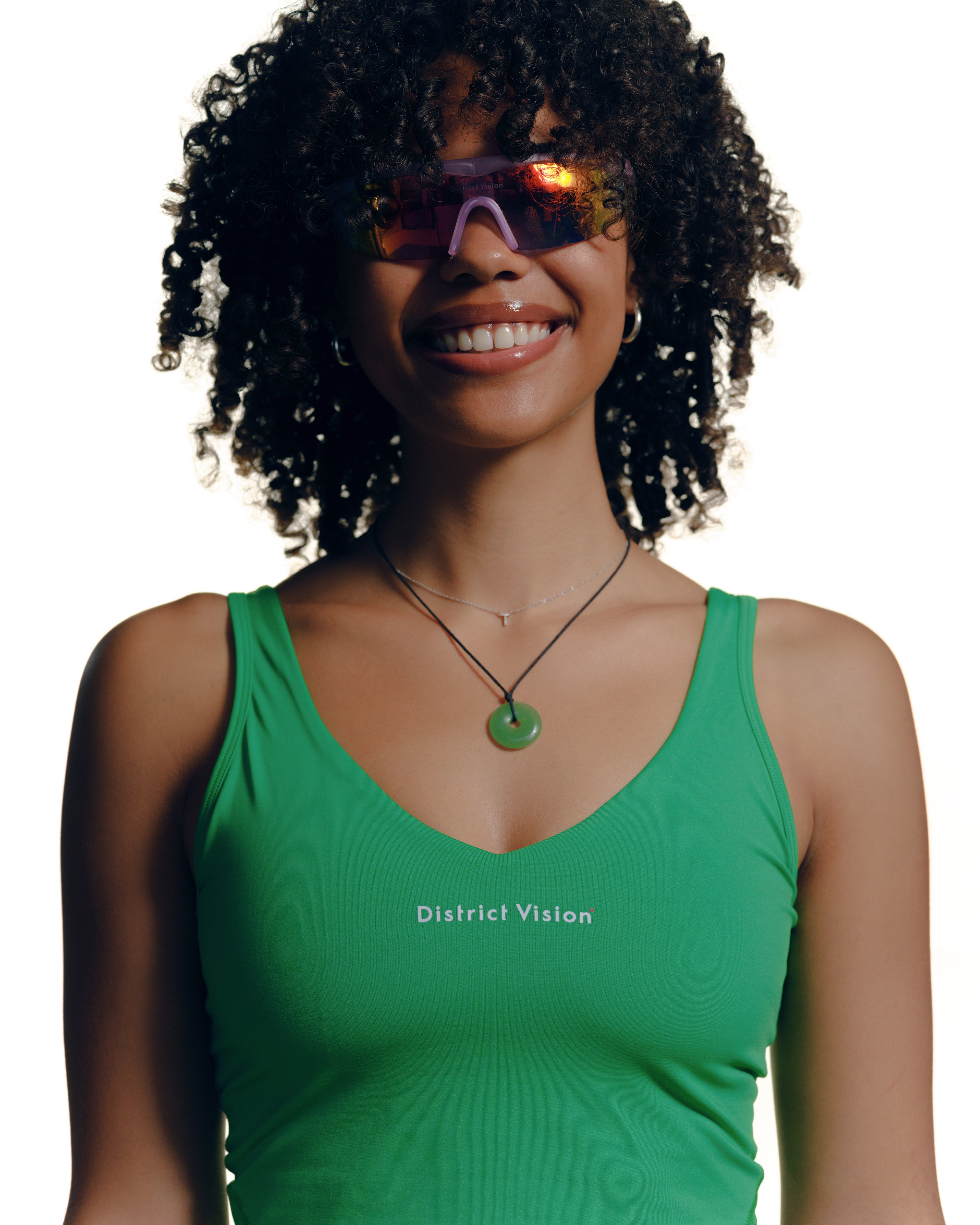 A woman wearing District Vision sunglasses and sports bra
