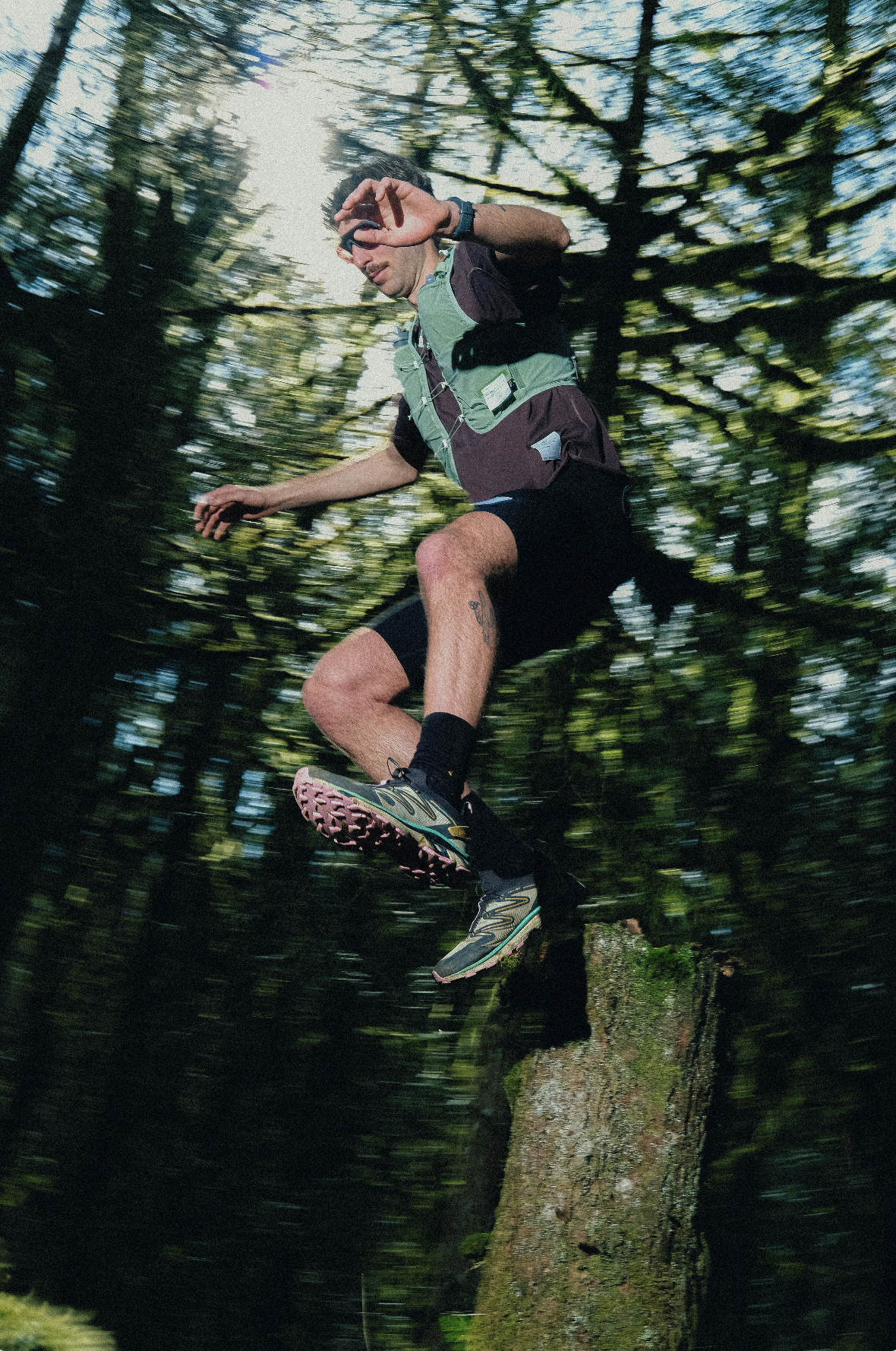 A man jumping in Satisfy running shorts, tops and vest