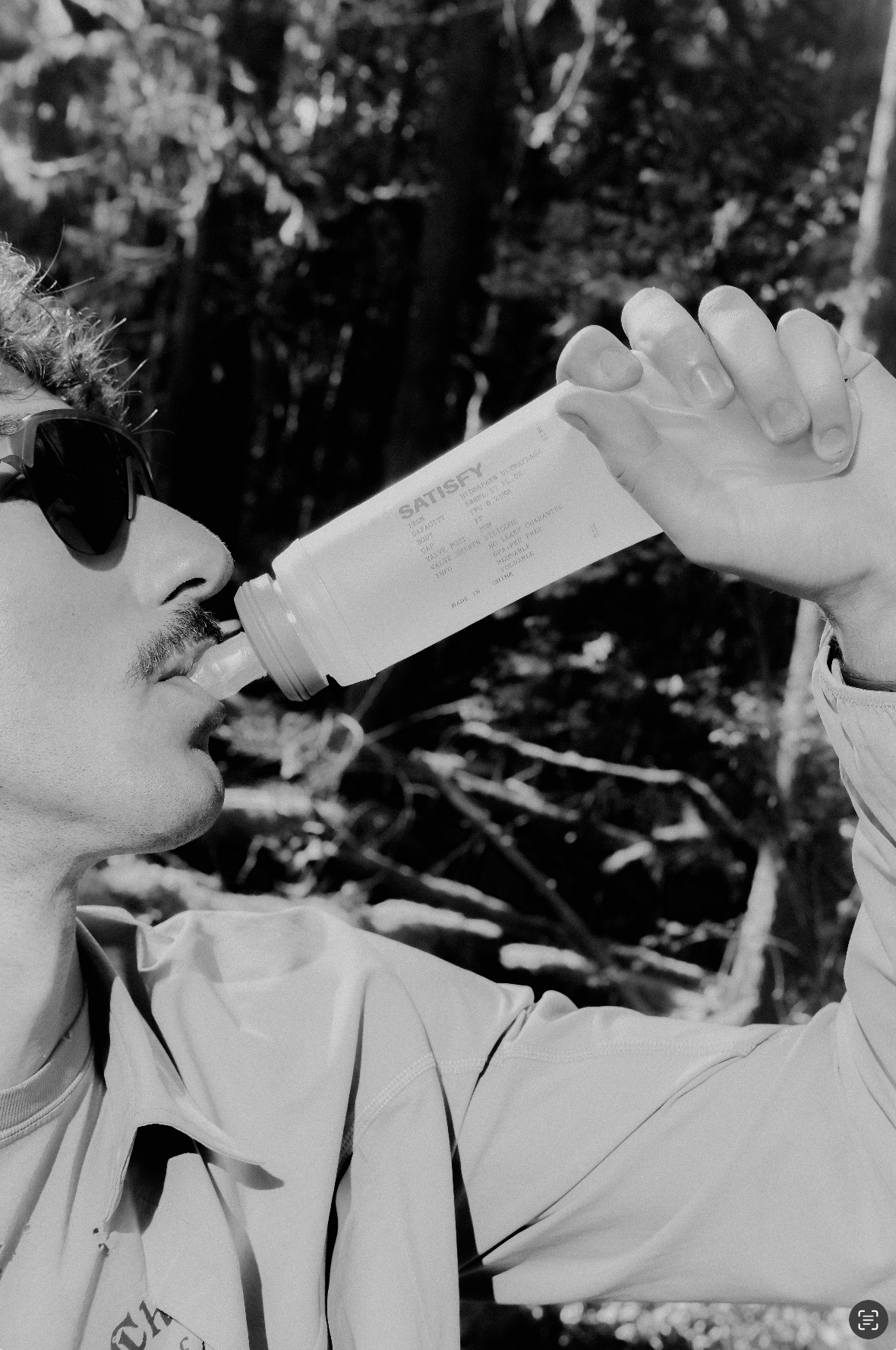 A man drinking from a Satisfy water bottle