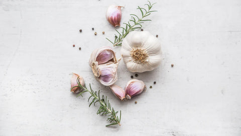 Fresh garlic cloves surrounded by immune-boosting supplements, symbolizing the natural defense against cold and flu provided by allicin.