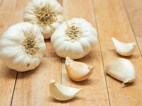 A close-up image of a garlic clove surrounded by immune-boosting supplements, illustrating allicin's role in nature's defense against cold and flu.