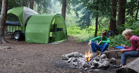 Kids around fire with LittleGiant Treehaus Camping Trailer