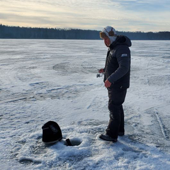 Tyler Standing on Ice Jigging for Fish