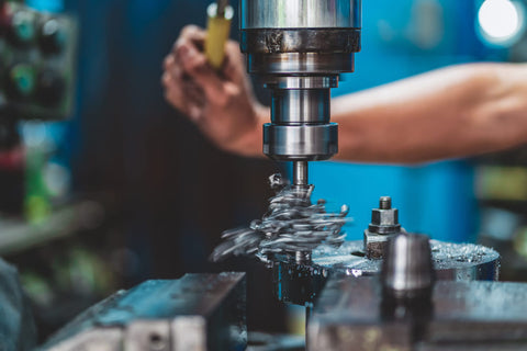 Professional machinist working with milling machine in metalworking factory