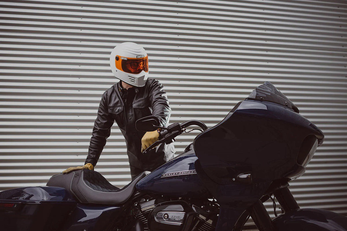 Rider finishing installation of Luimoto seat cover for Harley-Davidson motorcycle