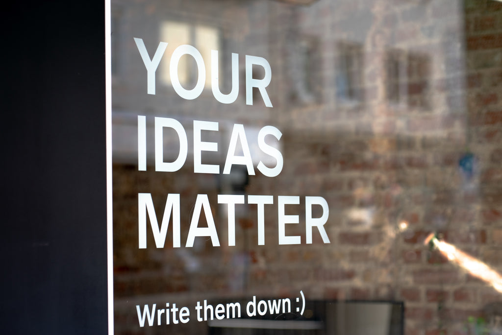 Ventanal en el que pone "YOUR IDEAS MATTER (write it down)".