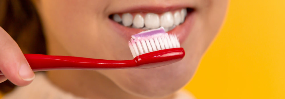 A person brushing their teeth to prevent gum disease