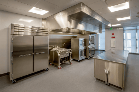 An industrial kitchen used for food catering with equipment operated using wheels and castors.