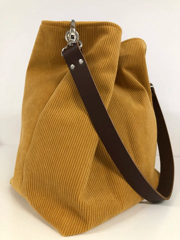 Le sac hobo en velours côtelé jaune moutarde, anse en cuir marron