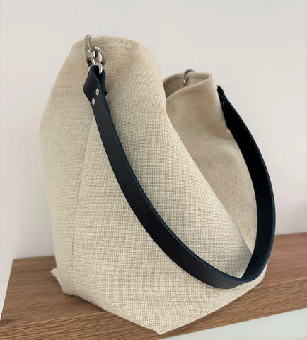 The hobo bag in ivory linen and navy blue leather handle