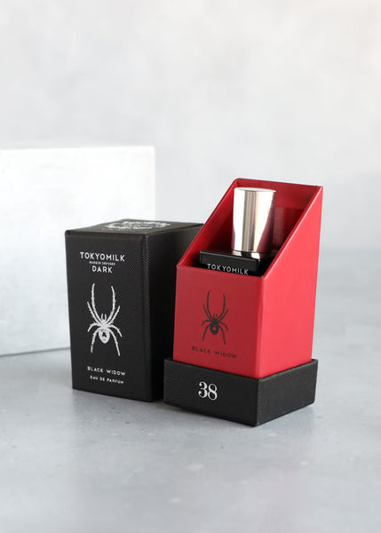 tokyomilk 38 black widow perfume, featuring a black and red perfume box with black glass perfume bottle with silver lid, and a white image of a black widow spider