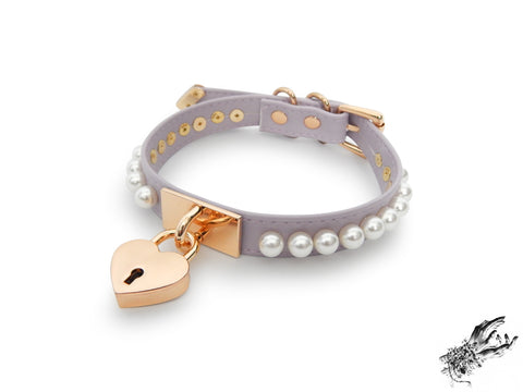 lilac and gold choker made of vegan leather, with a gold heart padlock in the centre and white pearl studs around either side