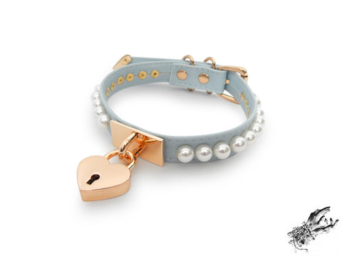baby blue and gold choker made of vegan leather, with a gold heart padlock in the centre and white pearl studs around either side