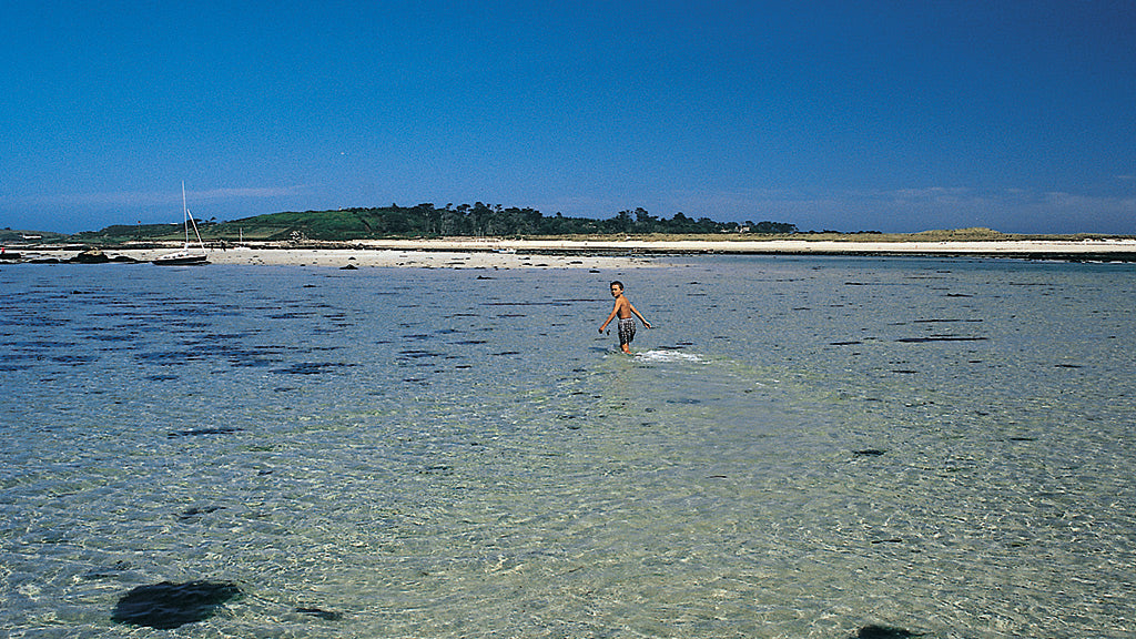 Boy wading between Samson and Tresco, Isles of Scilly