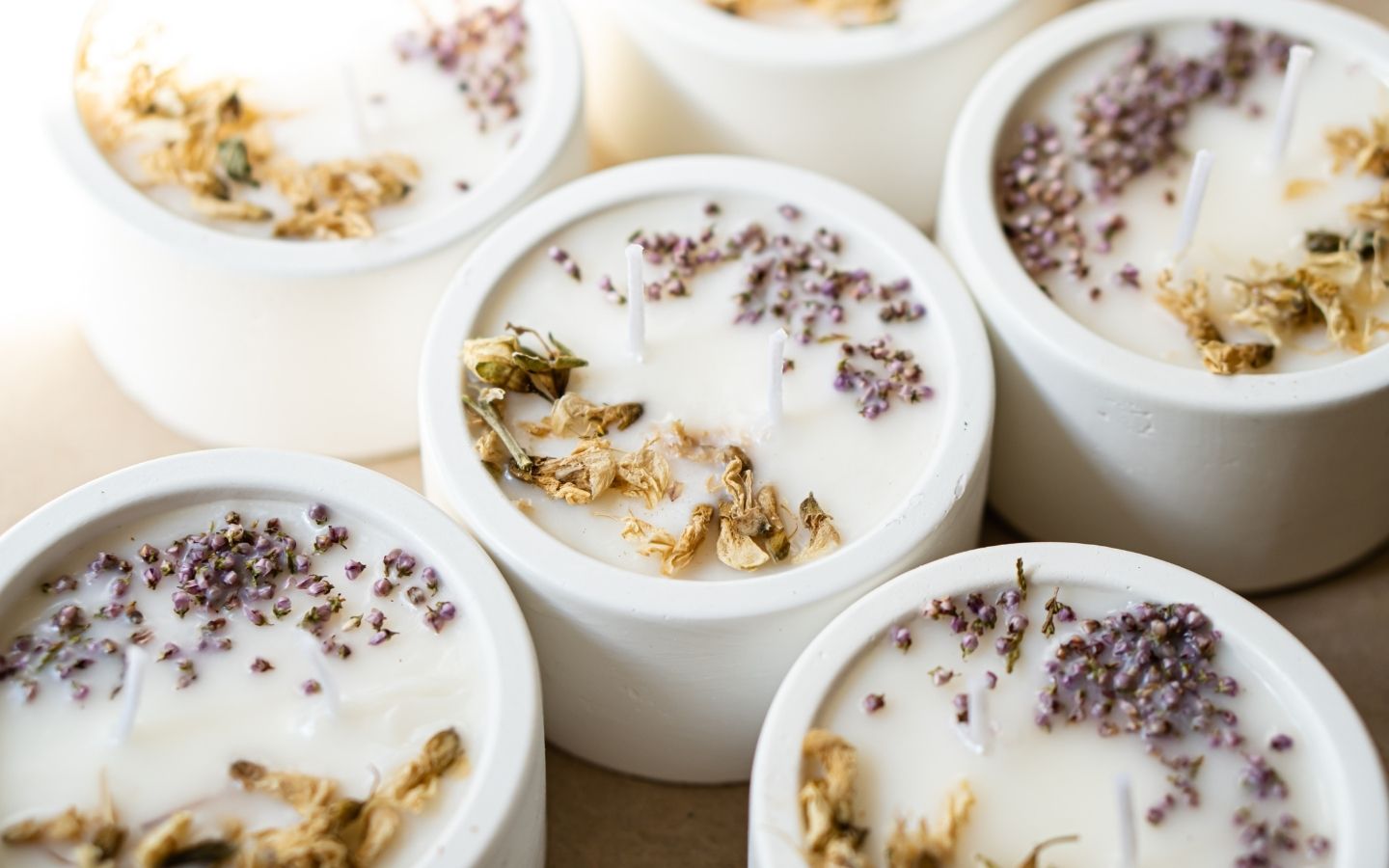 scented candles with dried flowers on the surface