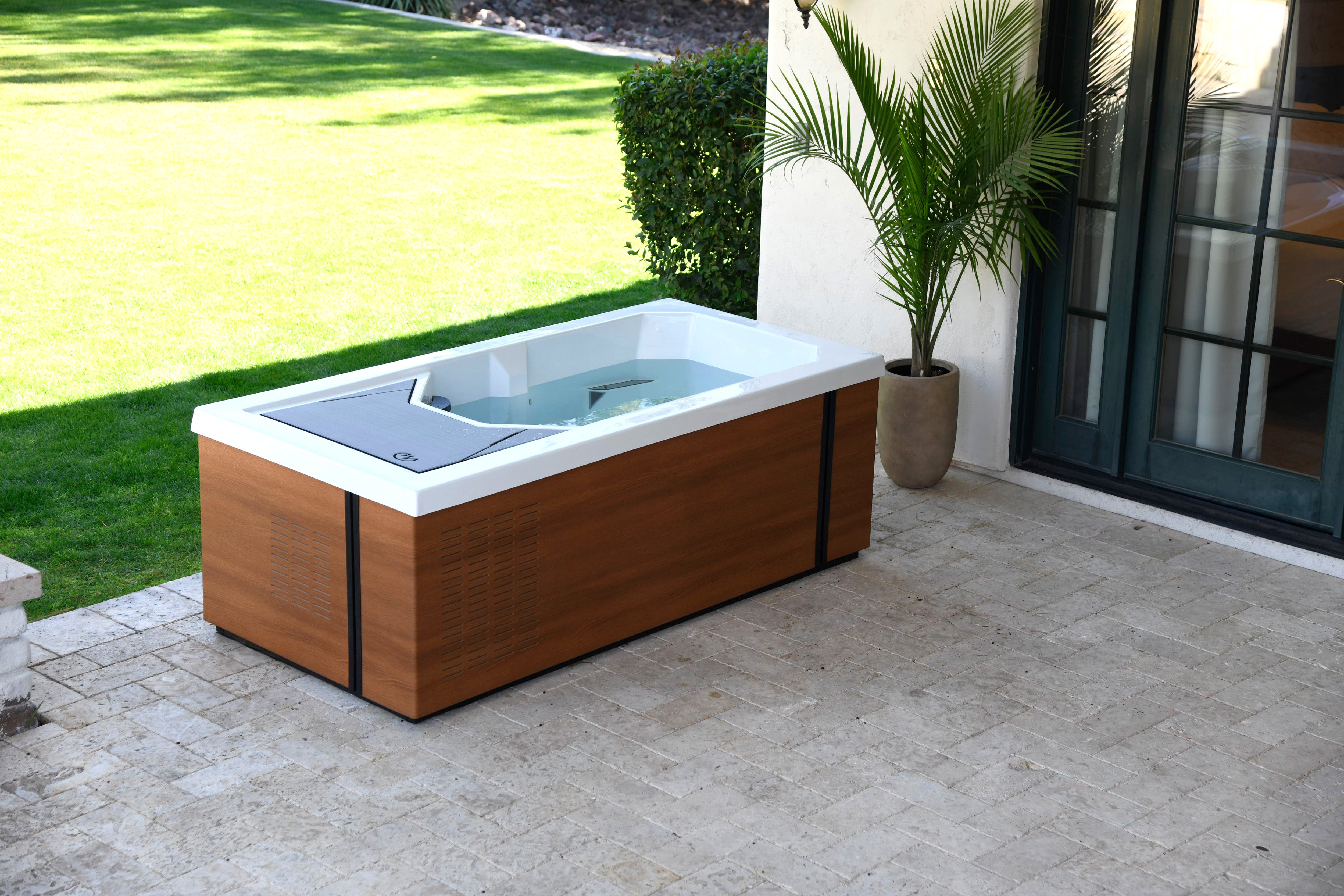 Alpine cold tub on a patio in front of grass