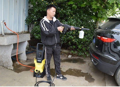 A imagem mostra um homem começando o processo de lavagem do seu veículo.