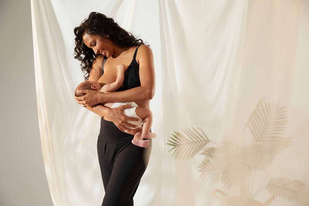 mother breastfeeding baby while standing