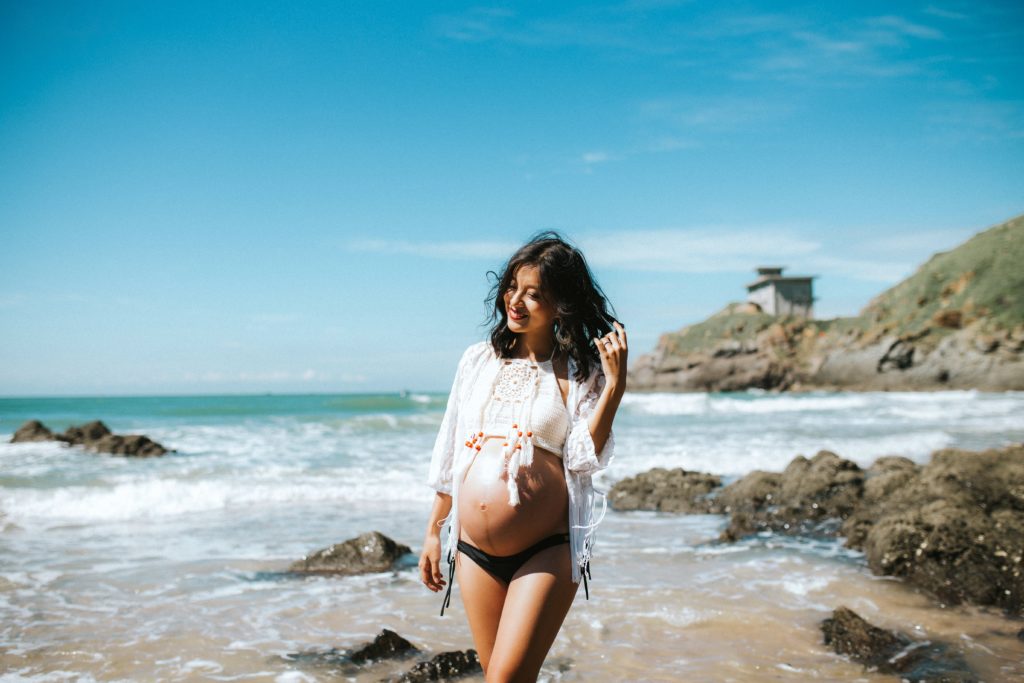 pregnant woman walking in the beach