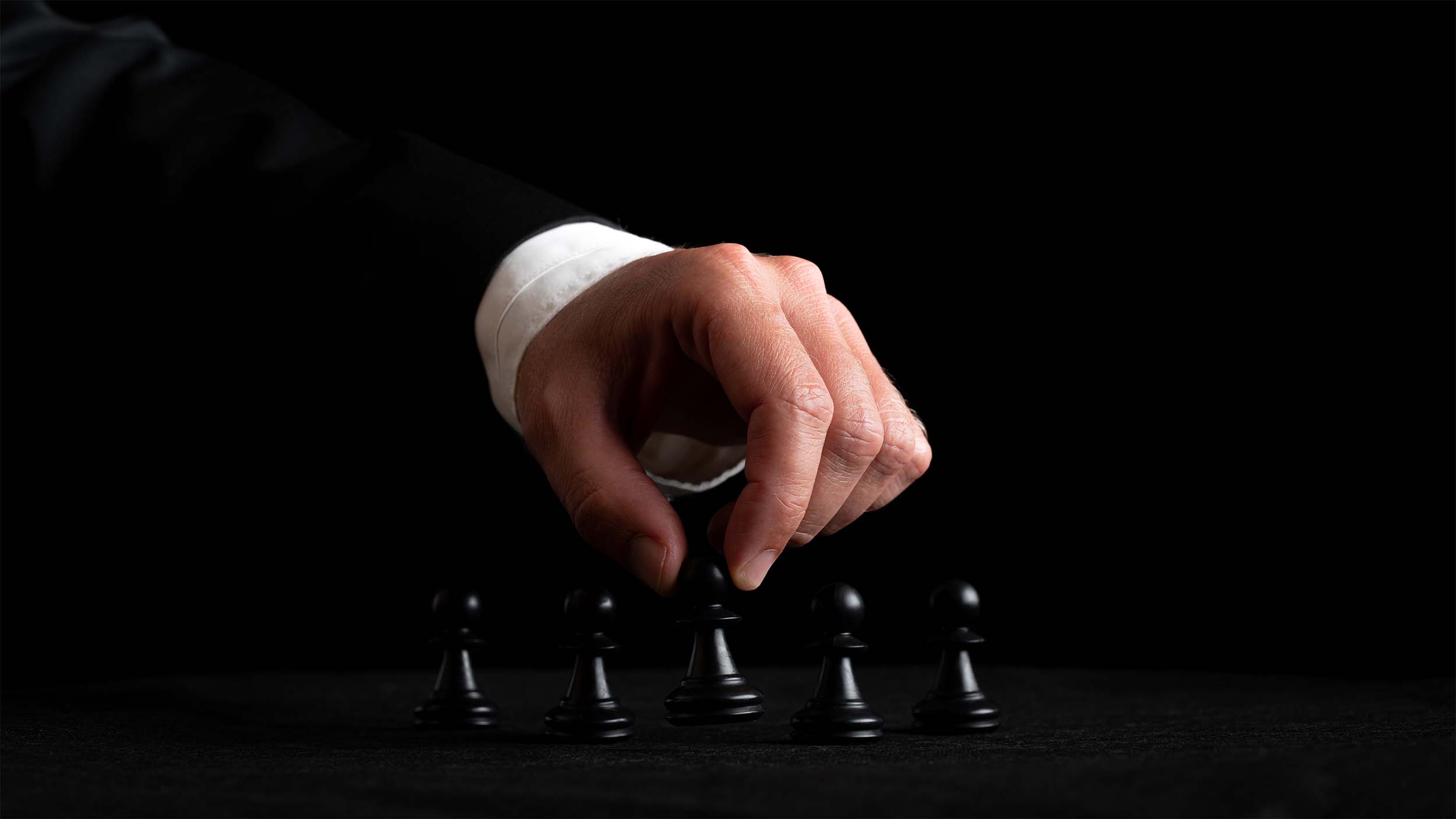 hand-businessman-arranging-chess-figures-conceptual-image-leadership-power-black-background.jpg__PID:7877816a-370c-4c90-80f3-d157f13a5022