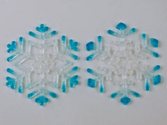 two delicate glass snowflakes with blue and clear