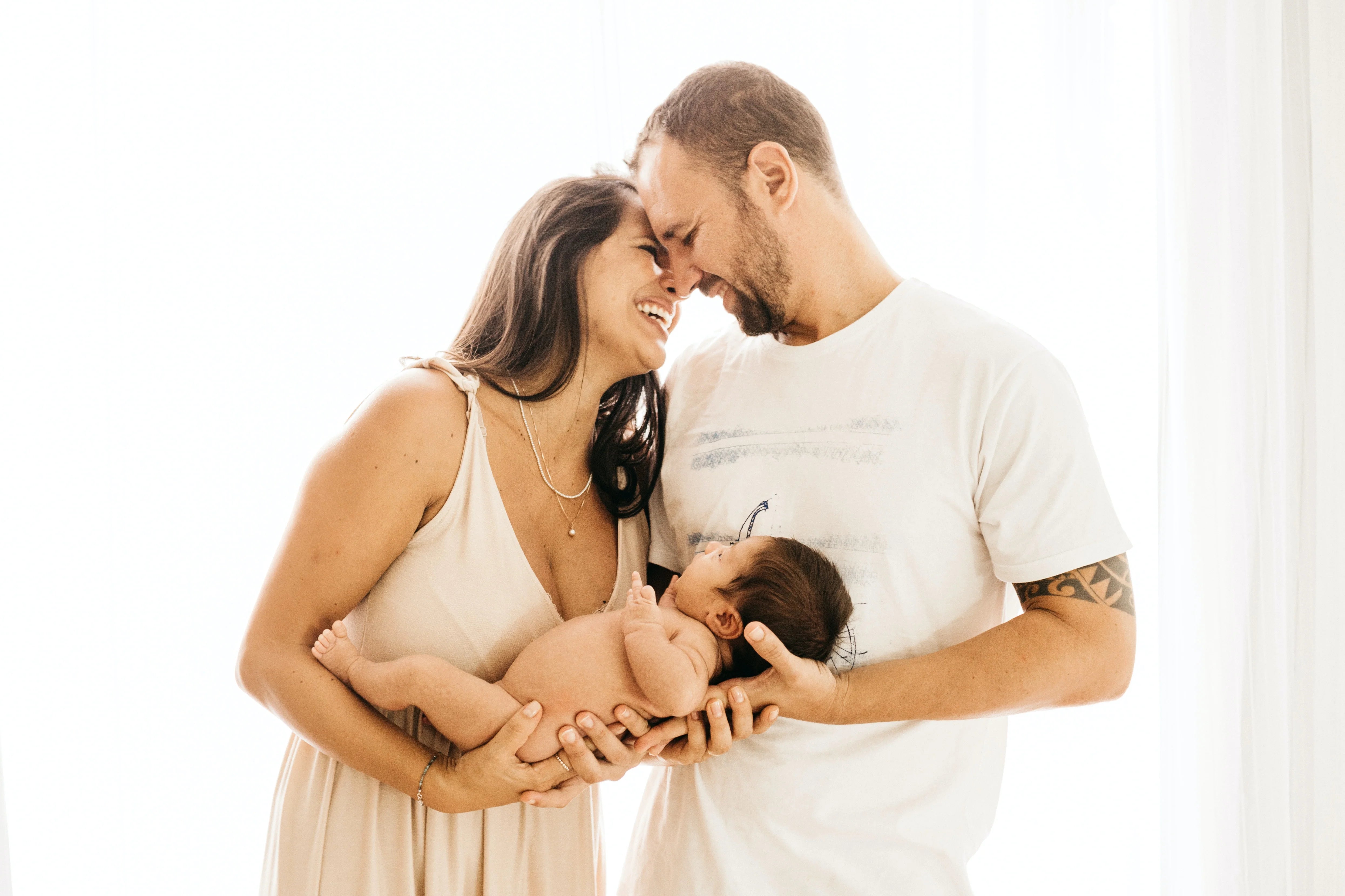 A joyful couple lovingly holding their newborn baby.