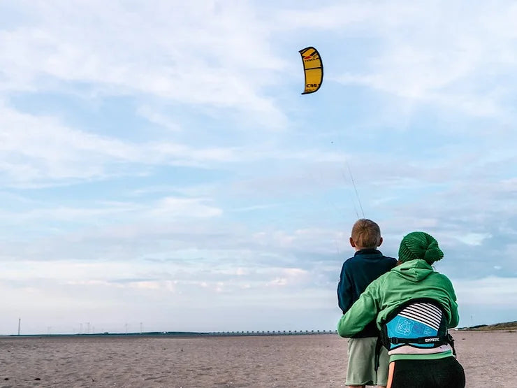 trainerkite üben am strand mit kind