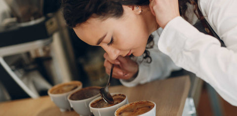 Woman cupping and smelling coffee
