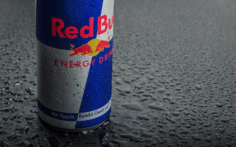 A can of red bull, which is an energy drink, ready to be drank.