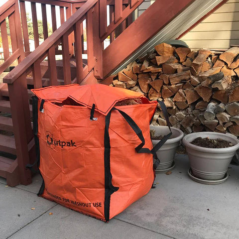 Outpak Debris Bag used for wood by a house.