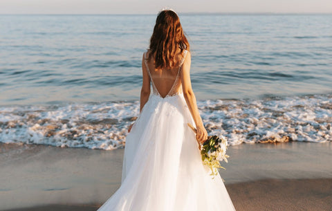 mariée en robe blanche au bord de la plage
