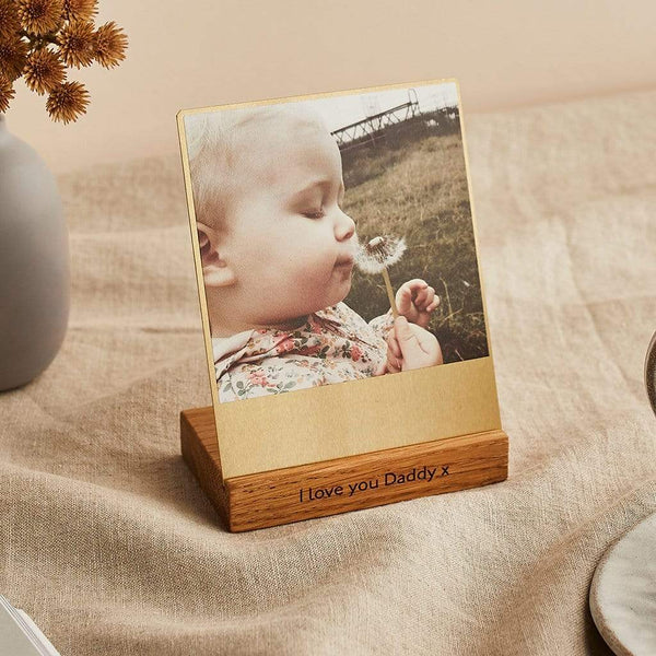 A photo of a young child printed onto a brass frame, with a wooden base engraved "I love you Daddy x"