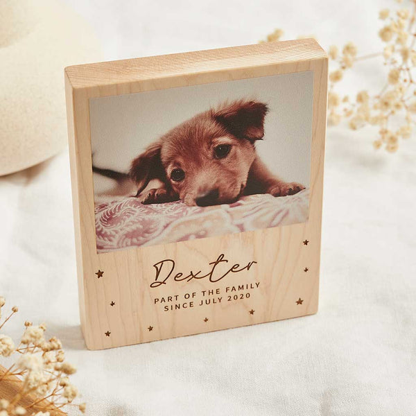 A wooden block printed with a photo of a brown puppy with the engraving "Dexter: part of the family since July 2020"