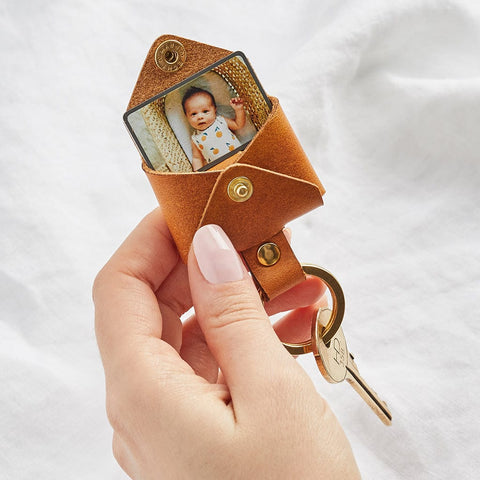 A brown leather envelope shaped keyring with a baby photo inside - handmade by Create Gift Love