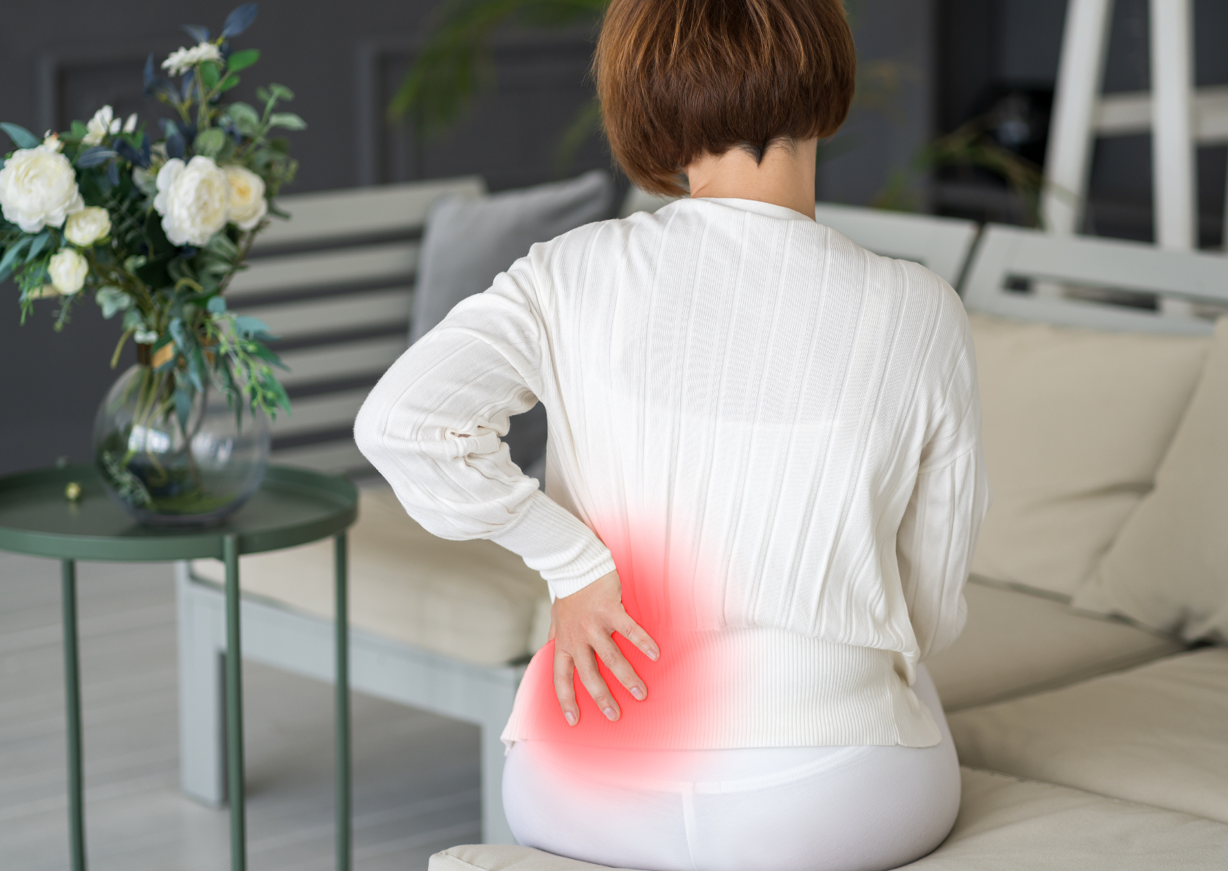 Can red light therapy help with osteoporosis? Woman with osteoporosis sitting in pain.