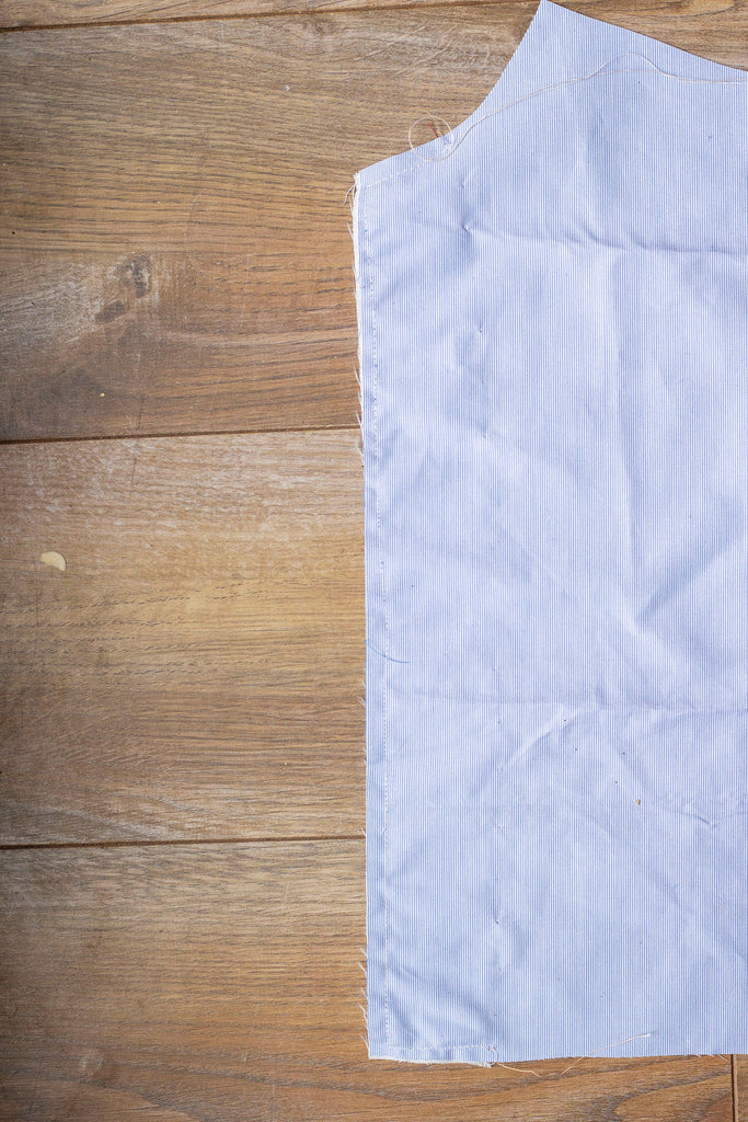 The right side of the blue garment where none of the red stitches can be seen. Part of the blue garment has been cropped from the right side of the frame