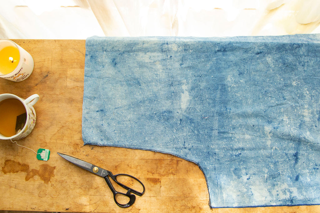 Light blue pant leg with finished crotch seam lying on wooden cutting board