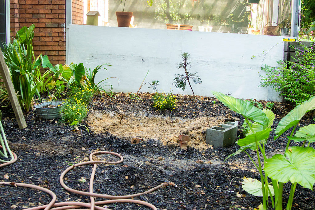 The same garden as mentioned above shown from the side. In this image, the slope of the yard is clearly seen by the slope of the white pergola behind the freshly begun pond