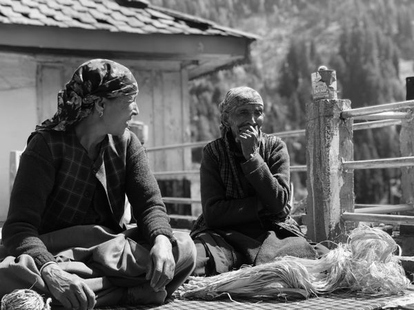 Elderly Himachali ladies sitting with hemp fibre kept in front