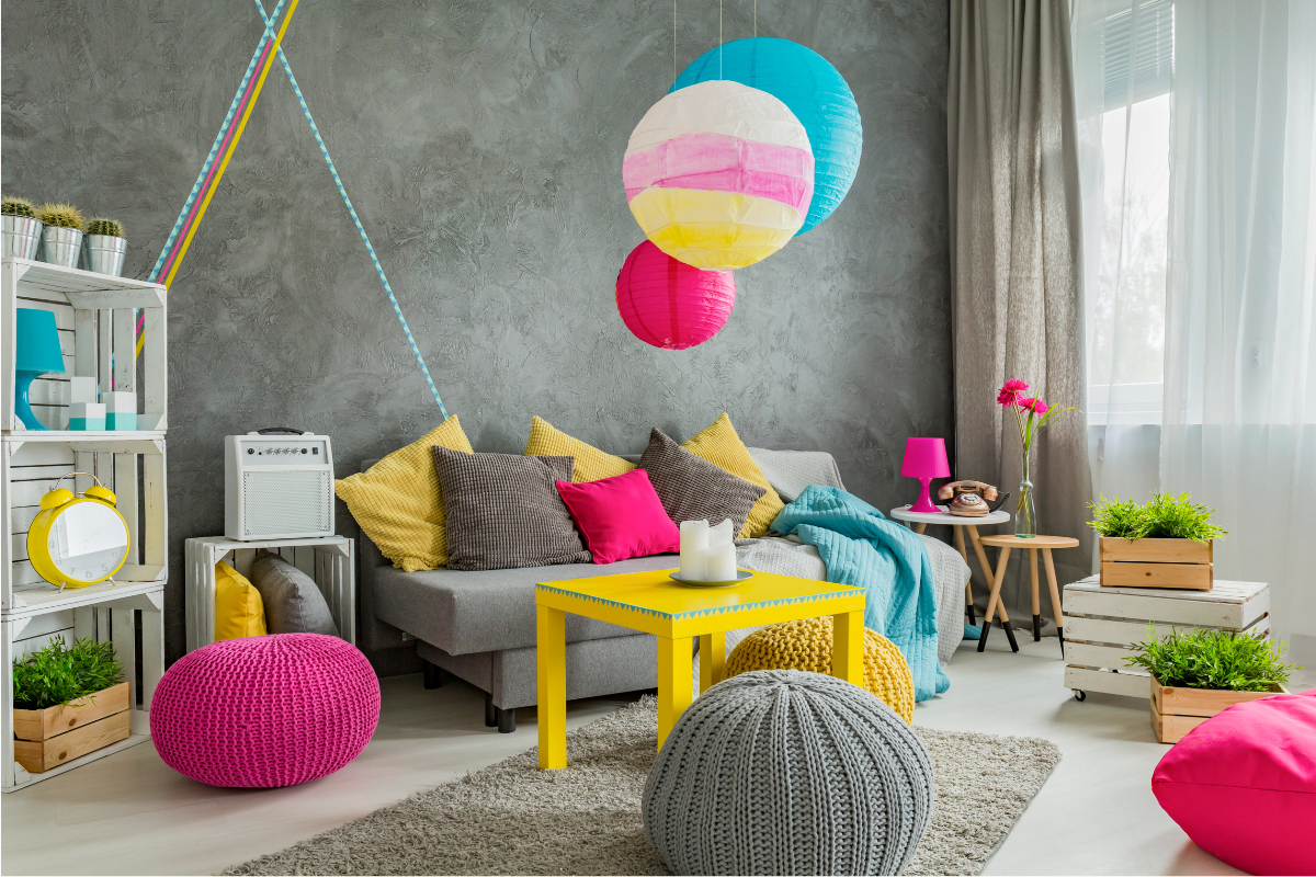 bedroom with gray walls with colorful hanging lanterns and plush floor cushions