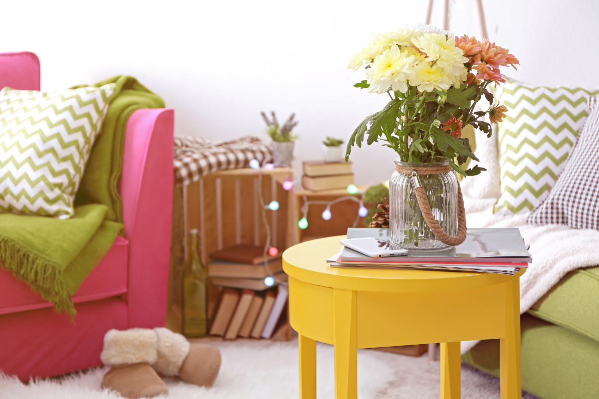 pink couch next to a yellow end table for an eclectic look