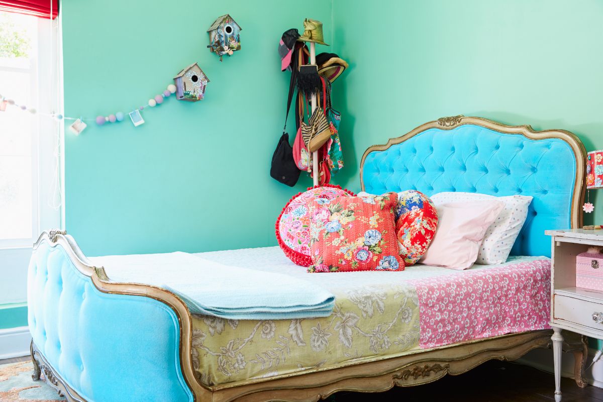 bedroom with blue walls, an old fashioned bed, and whimsical wall decor
