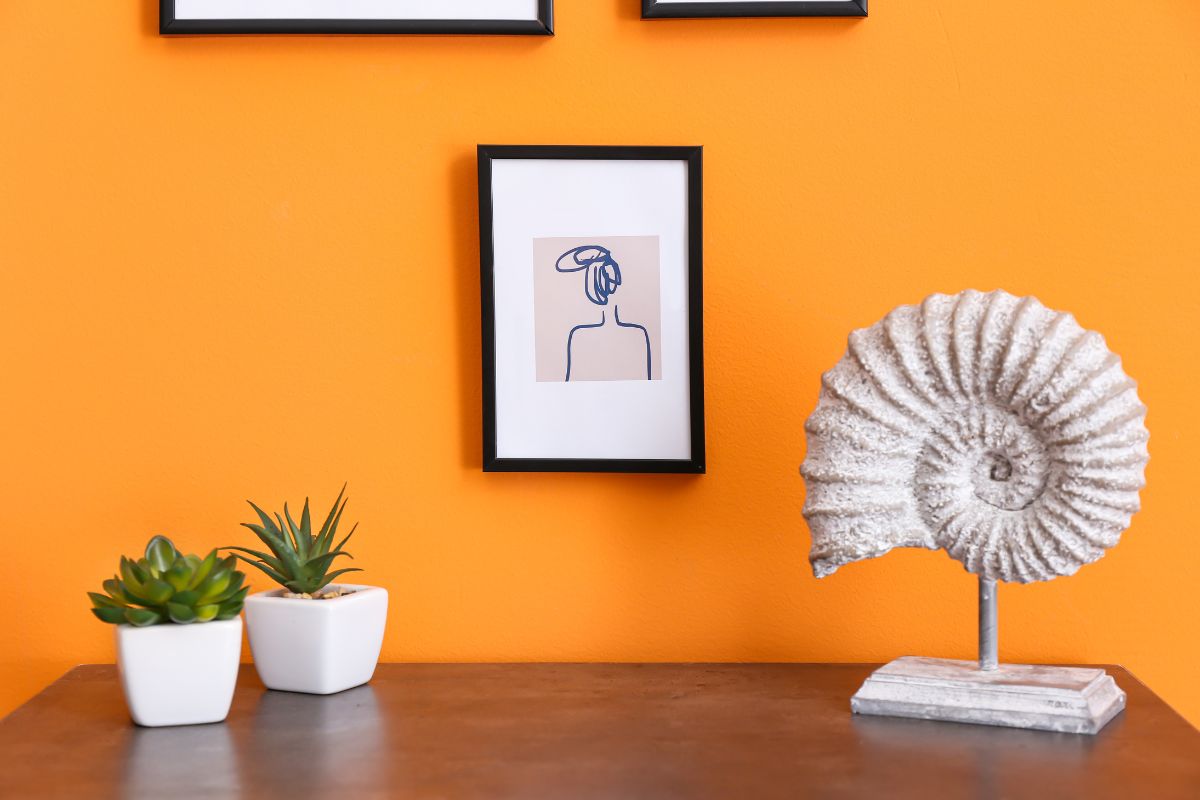 whimsical line art hanging on an orange wall