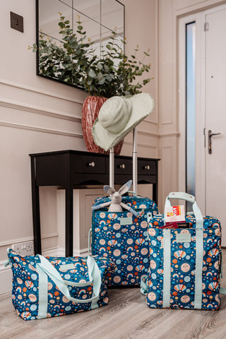 image shows the little luggage co suitcase, tote bag and backpack packed by the front door ready for holiday