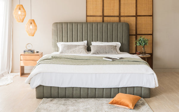 Luxurious upholstered bed with vertical channel headboard and mid-century bedside table, reflecting modern 2024 bedroom decor.