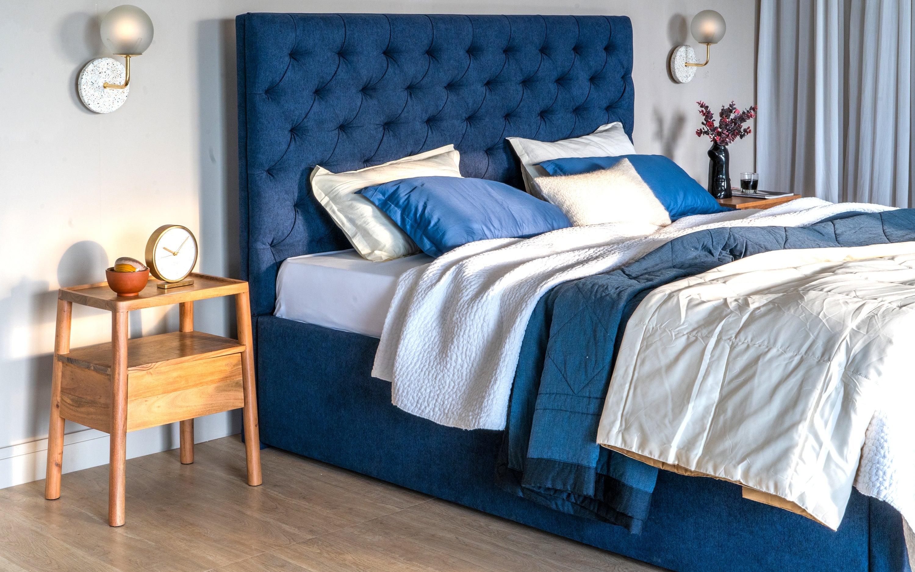 Luxury upholstered blue headboard with coordinating bedding and decor