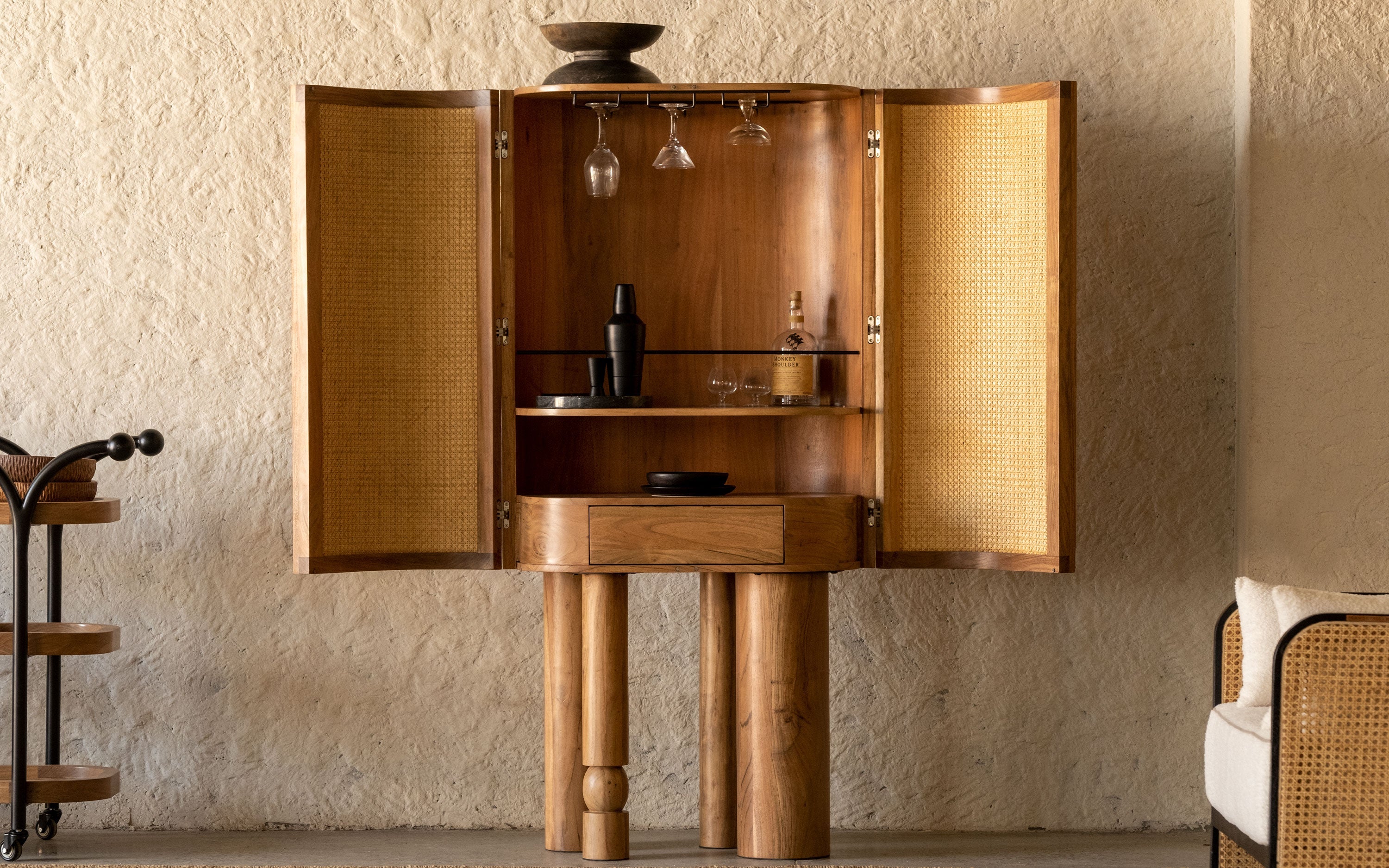 An elegant wooden bar cabinet with storage compartments and a natural finish, perfect as a home bar centerpiece.
