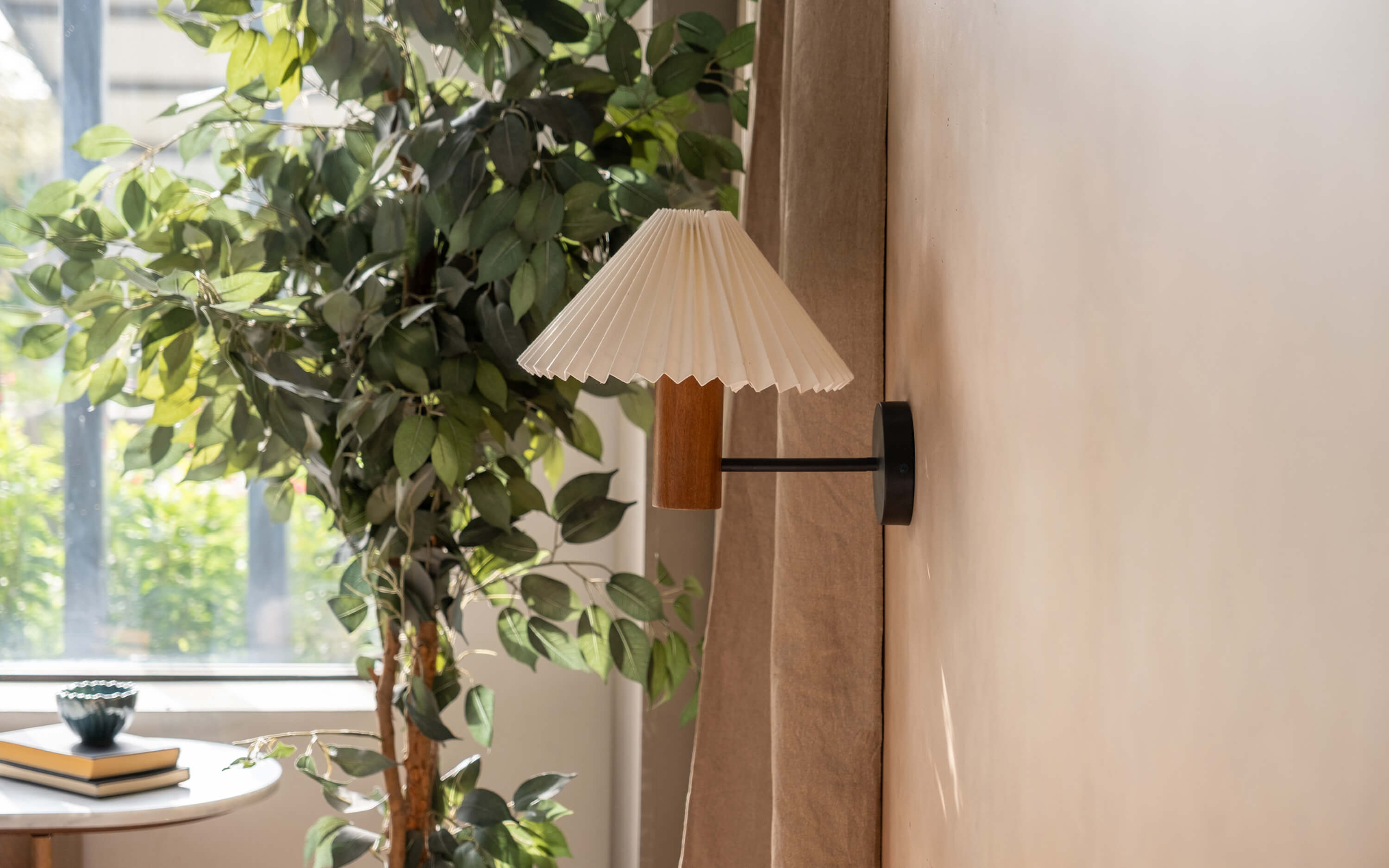 Artistic wooden wall lamp with a pleated shade, ideal for adding ambient lighting to a home adorned with wooden home decor items.