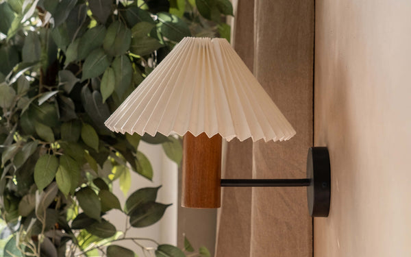 Vintage-inspired wall lamp with a pleated shade, an ideal housewarming gift for creating a warm and inviting atmosphere in a cozy nook