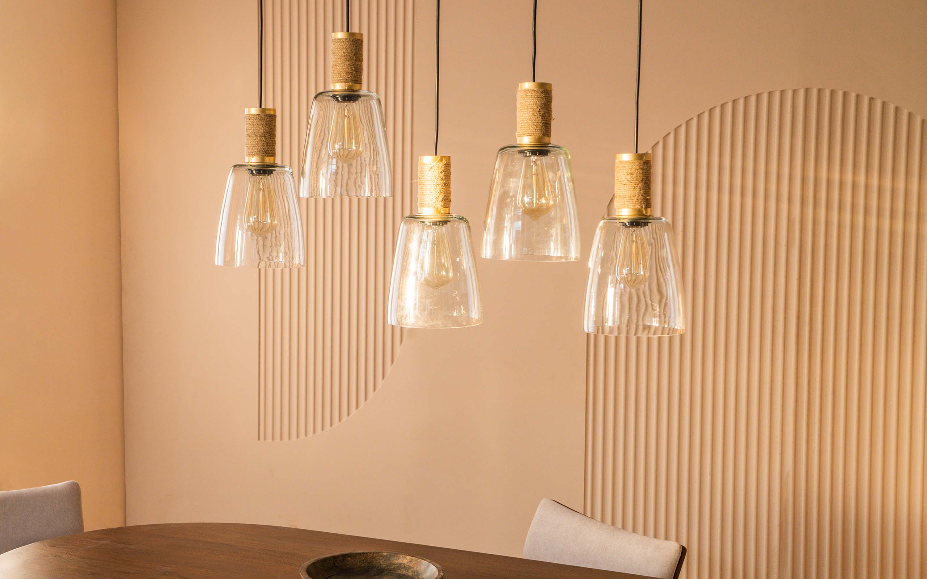 A selection of pendant lights with cork detailing and clear glass, showcasing a contemporary lighting option for living rooms